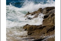 Waves crash on a rock jetty along the California coast line.